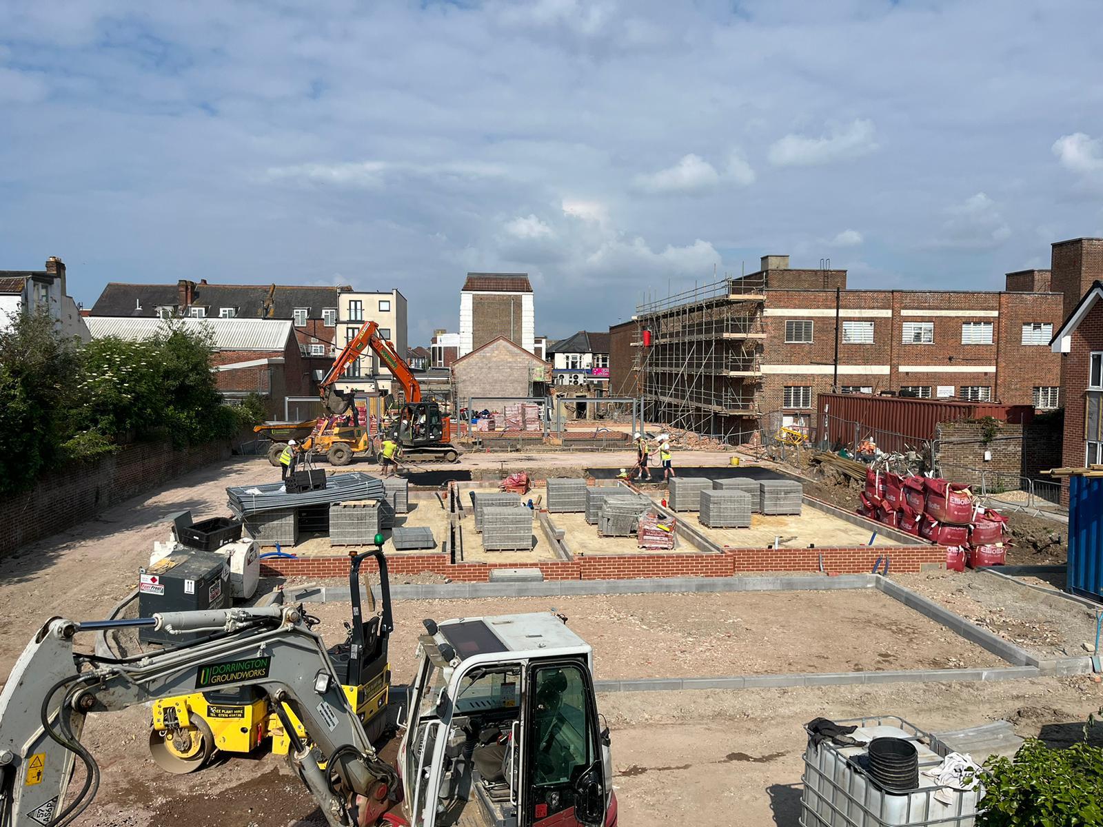 Urban construction site with foundation trenches and blockwork underway
