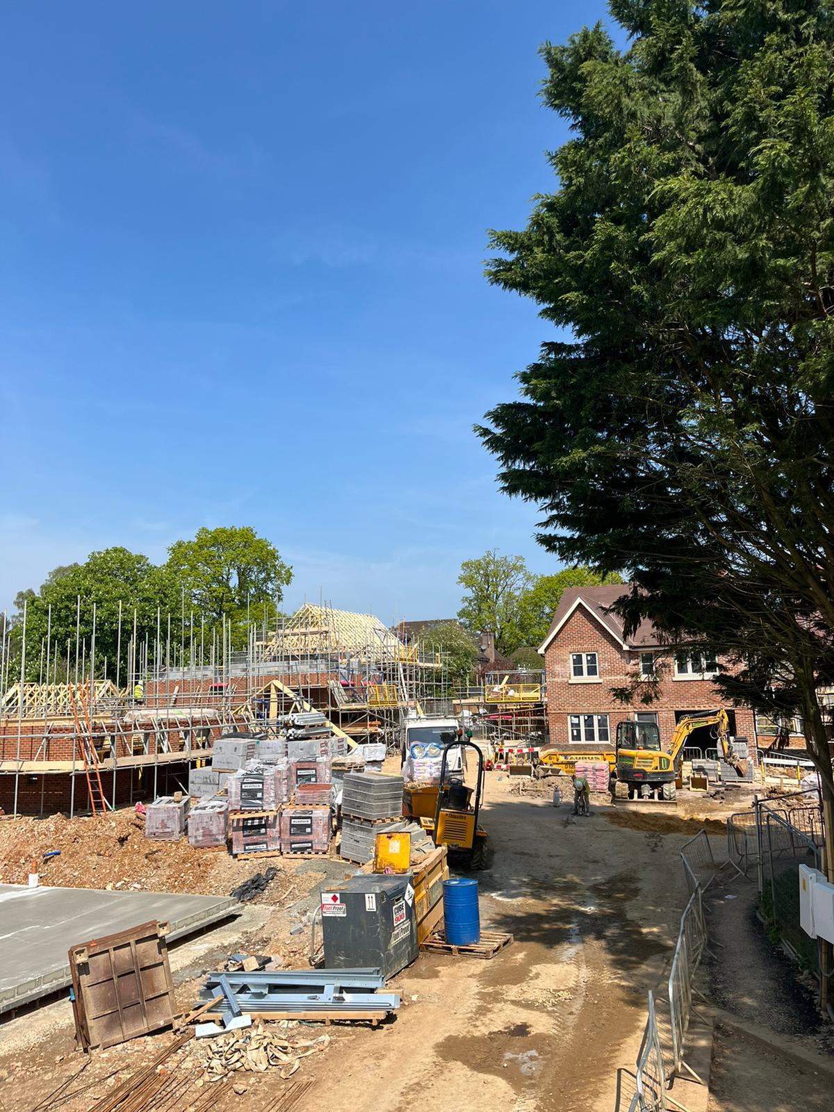 Active residential construction site with framed buildings and materials staging area